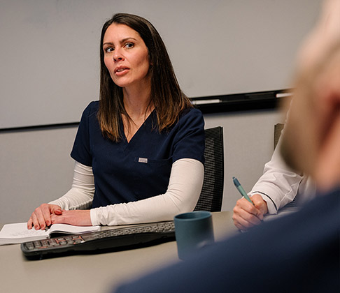 A St. Joseph's Health nurse participates in a group discussion about the best care options at a conference table.